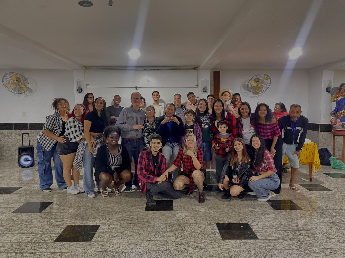 Grande grupo de estudantes, voluntários e educadores reunidos em confraternização na sede do instituto